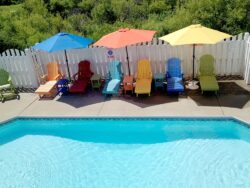Colorful chairs and umbrellas by a swimming pool.