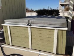 Outdoor hot tub with a closed, gray cover.